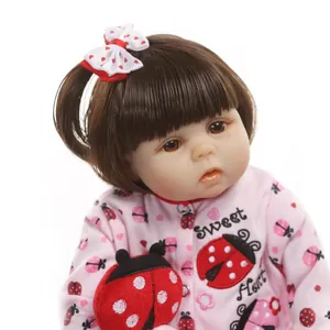Realistic reborn baby doll in pink ladybug outfit with sweet heart embroidery detail