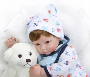 Close-up of lifelike reborn baby doll in bear print onesie with brown hair details