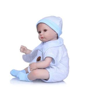Detailed view of reborn baby doll in blue striped outfit sitting against white background