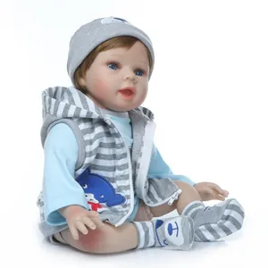 Poupée réaliste Reborn aux yeux bleus et gilet en tricot gris sur fond blanc pur