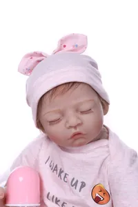Close-up of a sleeping reborn baby doll featuring realistic skin texture and long lashes