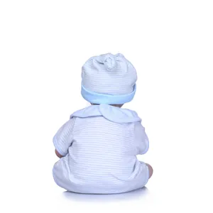 Detail of baby doll wearing a blue striped knit onesie and a knotted hat on white background