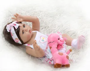 Détail d'une poupée reborn de 48 cm avec une peluche girafe sur un tapis en fausse fourrure