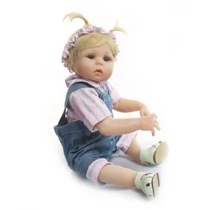 Détail d'une poupée Reborn réaliste avec chemise rayée et salopette en jean sur fond blanc