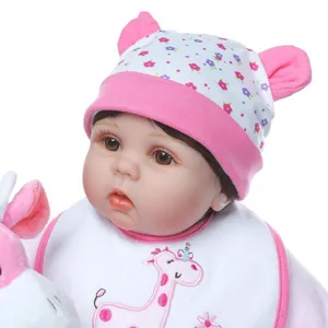 Realistische Reborn-Babypuppe mit Blumenmütze und Lätzchen mit rosa Giraffenprint