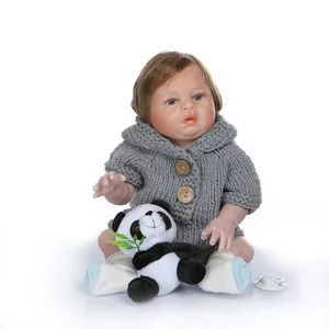 Detail of lifelike reborn baby doll in grey knit hoodie with panda plush toy
