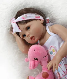 Gros plan d'une poupée réaliste avec yeux bleus et peluche girafe rose en robe