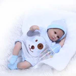Detailed view of reborn baby doll in blue striped outfit with bottle on plush carpet