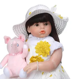 Lifelike reborn baby doll in polka dot dress with sun hat and pink plush elephant toy