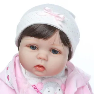 Gros plan d'un visage réaliste de poupée reborn avec yeux bleus et bonnet rose à pois