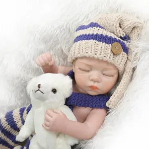 Poupée Reborn réaliste dormant sur un tapis en fausse fourrure blanche en tenue tricotée