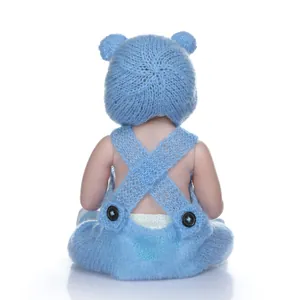 Rear view of a lifelike baby doll wearing a blue mohair knit hat with bear ears