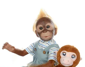 Close-up of lifelike baby orangutan reborn doll with blue striped overall outfit