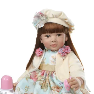 Realistic reborn toddler doll with long brown hair, floral dress and pink accessories
