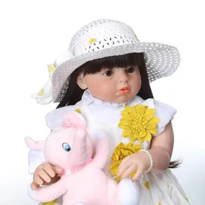 Lifelike reborn baby doll in white sunflower dress with a pink plush elephant toy