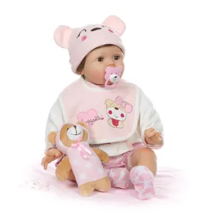 Realistic reborn baby doll with blinking eyes, pink knit hat, and brown teddy bear toy