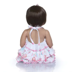 Vue arrière de poupée reborn avec carré brun en robe à volants et motifs de desserts
