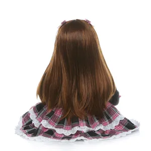 Reborn toddler doll with long brown hair, pink clips, and lace plaid skirt, back view
