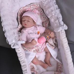 Realistic reborn baby doll in pink sleepwear sleeping in a lace cradle with bottle