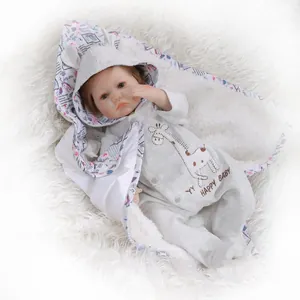 Realistic reborn baby doll in grey waffle romper and giraffe cape on white plush mat