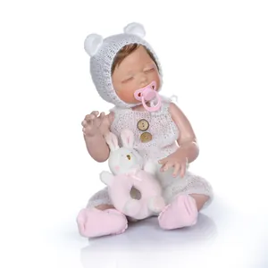Lifelike reborn baby doll in white bear outfit with plush bunny and pink pacifier