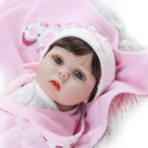 Poupée Reborn réaliste avec yeux bleus et couverture en peluche rose de près