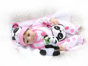 Detalle de muñeca reborn con mono de panda, gorro a juego y peluche de panda