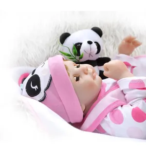 Muñeca Reborn realista con traje de panda rosa sobre piel sintética blanca suave