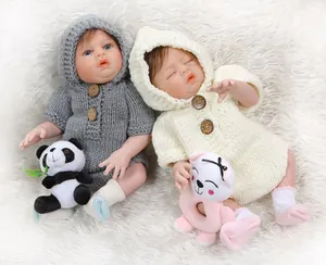 Close-up of realistic twin baby dolls in knit rompers on white faux fur background
