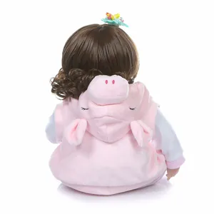 NPK lifelike reborn doll with long wavy brown hair and pink piglet hoodie outfit