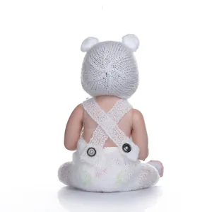 Rear view of lifelike newborn baby doll in floral knit romper and bear ear hat