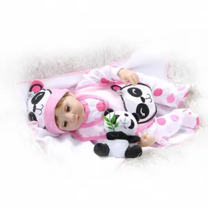 Muñeca bebé reborn realista con traje de panda rosa y peluche en alfombra suave