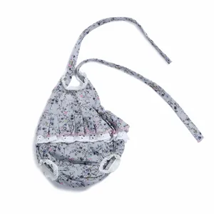 Dettaglio di pagliaccetto neonato a fiori con pizzo bianco e raffinati volant sul petto