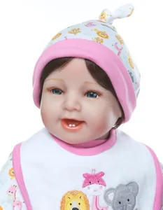 Detail of reborn baby doll with brown hair, blue eyes, and embroidered animal bib