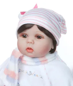 Detail of reborn baby doll featuring realistic eyelashes and pink striped knit hat
