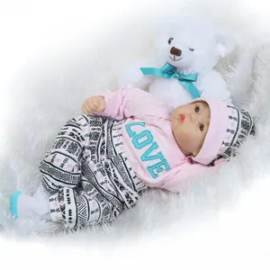 Realistic soft silicone reborn baby doll in pink love outfit with plush bear accessory