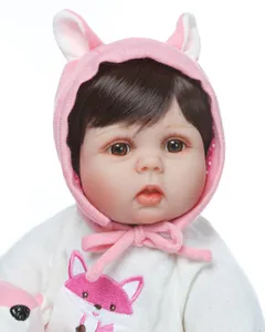 Close-up of silicone reborn doll with pink fox embroidery and knitted bunny hat