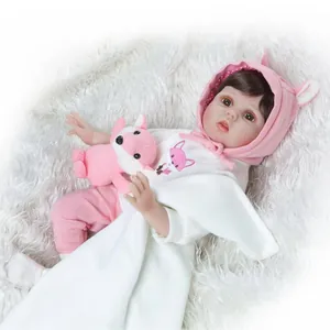 Realistic reborn baby doll in pink knit hat and fox outfit with plush toy accessory