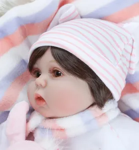 Detailed close-up of a lifelike reborn baby doll featuring striped hat and matching scarf