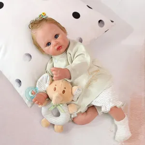 Realistic reborn baby doll with curly hair, pajamas, elephant rattle and blue pacifier