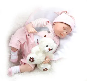 Slapende reborn babypop in roze gestreepte outfit met witte pluchen beer op zacht tapijt