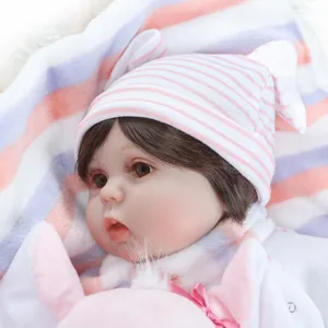 Close-up of lifelike reborn baby doll with brown eyes and pink striped knit hat