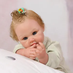 Realistic reborn baby doll with curly blonde hair, blue eyes and light green outfit