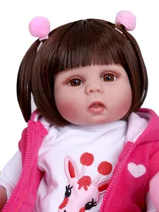 Gros plan d'une poupée réaliste avec couettes brunes et gilet à capuche rose