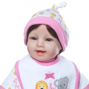 Realistic reborn baby doll featuring blue eyes and cartoon embroidery outfit on white background