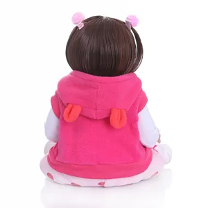Vue arrière de la poupée bébé réaliste de 48 cm avec gilet rose et pantalon à pois
