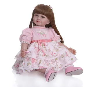 Realistic silicone doll with long brown hair in a floral pink lace dress on white background