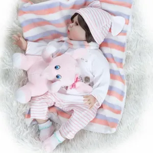 Realistic reborn baby doll in pink stripe outfit with matching elephant plush toy