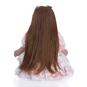 Realistic reborn girl doll with long brown hair, pink lace dress and red hairbows