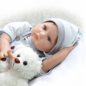 Detailopname van een reborn babypop met blauw gestreepte muts en witte pluche teddybeer